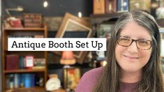 a woman with glasses is standing in front of bookshelves and she has the words antique booth set up above her head