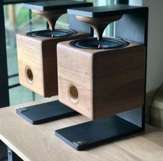 two wooden speakers sitting on top of a table