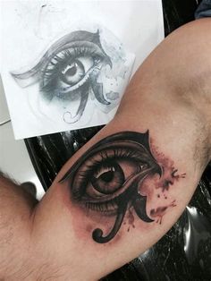 a man's arm with an eye tattoo on it