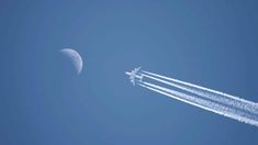 two jets are flying in the sky near the moon