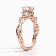 a rose gold engagement ring with an oval diamond center and twisted vine design on the band