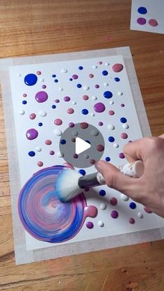 someone is painting circles with paint on paper