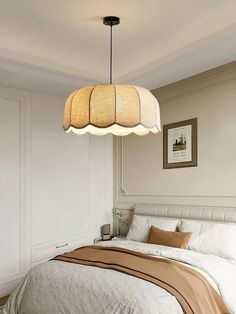 a bedroom with a bed, lamps and pictures on the wall above it that are hanging from the ceiling