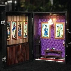 an open dollhouse with pictures on the wall