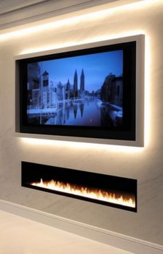 a television mounted on the wall above a fire place in a room with white walls