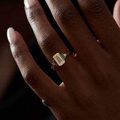 a woman's hand with a ring on it and a diamond in the middle