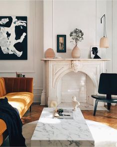 a living room filled with furniture and a fire place in front of a white fireplace