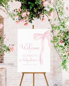 a welcome sign with pink flowers and greenery