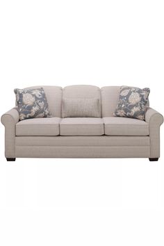 a beige couch with pillows on it and two blue throw pillows in front of it