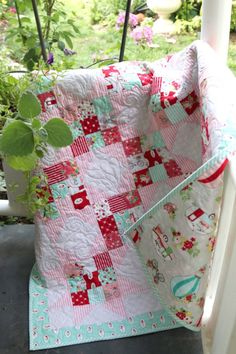 a quilted bag sitting on top of a porch next to a potted plant