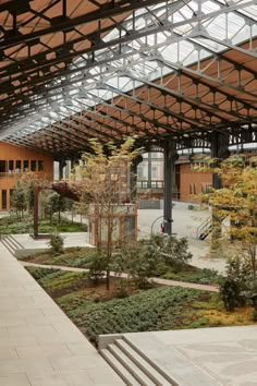 the inside of a building with many plants and trees in it's center area