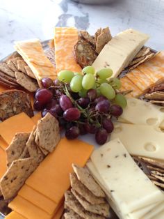 an assortment of cheeses and crackers on a plate