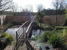 a wooden bridge crossing over a small pond