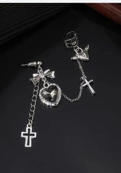 Embrace the goth aesthetic with our Heart Cross Chain Earrings. Featuring a black heart-shaped stone with a cross and bow, along with heart with wings accessory details. The combination with an ear cuff adds an extra edge to these zinc alloy earrings, creating a cool and unique style. Goth aesthetic Black heart shaped stone design with cross & bow Heart with wings accessory details Combined with ear cuff Zinc alloy Package: 1 piece Y2k Grunge Aesthetic, Cross Bow, Gothic Heart, The 90s Fashion, Hip Hop Fashion 90s, Goth Earrings, Aesthetic Jewelry, Heart With Wings, Cross Chain