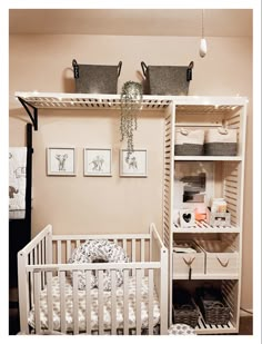 a baby's crib in the corner of a room next to a wall with pictures on it