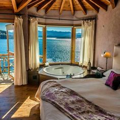 a bedroom with a jacuzzi tub overlooking the water