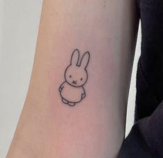 a small rabbit tattoo on the arm and leg, with an outline of a bunny in it's body