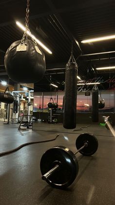 an empty gym with punching bags and boxing gloves