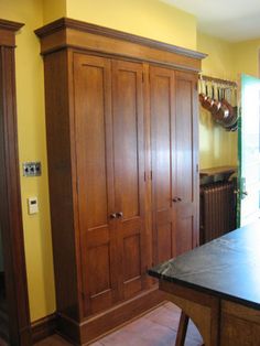 a kitchen with yellow walls and wooden cabinets