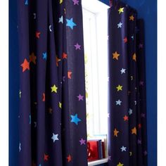 a window with stars painted on it and curtains in front of the window are open