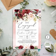 an elegant wedding card with flowers and greenery on the front, in pink tones