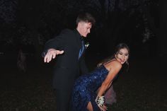 a woman in a blue dress dancing with a man in a black suit and tie