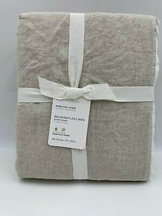 the product is wrapped in grey linen and has a white ribbon on top of it