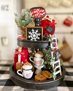 a tiered tray filled with christmas decorations