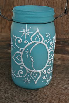 a blue mason jar sitting on top of a wooden table next to a metal chain