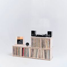 an old record player is sitting on top of a shelf with several records in it