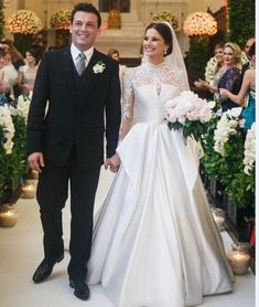 a bride and groom are walking down the aisle