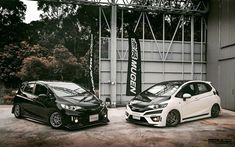 two cars parked next to each other in front of a building