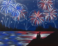 two people sitting on a rock watching fireworks go off in the night sky over water