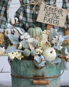 a bucket filled with lots of different types of flowers next to a sign that says keeper of the patch