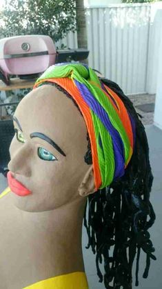 a mannequin head with multicolored dreadlocks on it's head