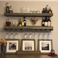 there are three shelves with wine glasses and bottles on them, along with two framed pictures