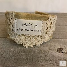 Quote: CHILD OF THE UNIVERSE This boho-style cotton cuff features layers of pale yellow fabric stitched together and cushioned with vintage crochet. Text is printed on colorfast fabric with heat-set ink for durability and easily cleans with a wet wipe. It closes with a vintage button and stretchy loop.  Measurements: 7 1/4" L by 1 3/8" W Fits a wrist size approximately 6 3/4" to 8" Bracelet fit wrists: S, M, L Always fits a smaller wrist just a bit looser. If you have a wrist smaller then 6 3/4" Crochet Bracelet Tutorial, Yellow Cotton Fabric, Fabric Cuff Bracelet, Boho Cuff Bracelet, Child Of The Universe, Vintage Cuff Bracelet, Boho Cuff, Crochet Jewelry Patterns, Womens Cuff Bracelets