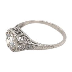 This beautiful antique piece was handcrafted in the early twentieth century. This Edwardian ring features a gorgeous 0.90 carat diamond in the center. The center diamond grades approximately an I in color and VS2 in clarity. The setting is platinum and features four small diamond accents, darling filigree accents, antique hand engraving, as well as fine milgrain accents. This ring is a sweet, simple, solitaire style, and overall a wonderful antique piece. The ring is currently a size 6 1/2. Comp Edwardian Ring, Platinum Engagement Ring, Platinum Diamond Engagement Rings, Platinum Engagement Rings, Jewelry Rings Engagement, Hand Engraving, Ring Verlobung, Platinum, Engagement Ring