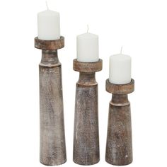 three wooden candlesticks with white candles in them