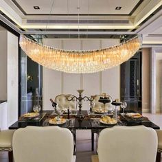 a dining room with chandelier hanging from the ceiling and white chairs around it