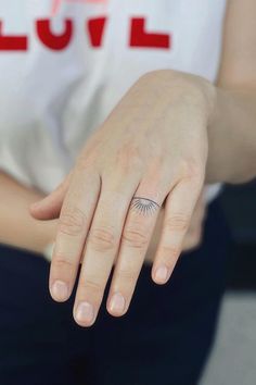 a woman's hand with a small ring on it and the word love written across her middle finger