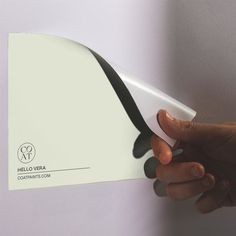 a hand holding a white and black business card