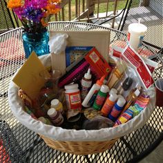 a basket filled with craft supplies sitting on top of a table