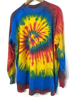 a tie - dyed shirt hanging on a hanger