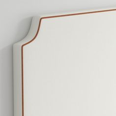 a close up of a white headboard with brown trim