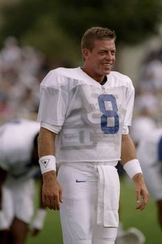 a man standing on top of a field wearing a football uniform