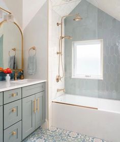 a bathroom with blue and white tile on the floor, sink, mirror, and bathtub