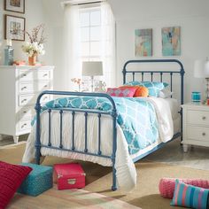 a bed room with a neatly made bed and colorful pillows