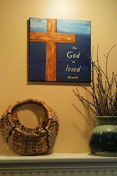 two vases and a cross on top of a mantle