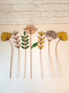 a group of flowers sitting on top of a white wall